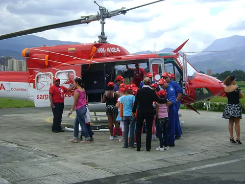 Niños y personal médico junto a un helicóptero de rescate