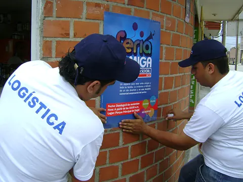 Equipo de logística pegando afiches de la Feria Amiga de Banco Caja Social