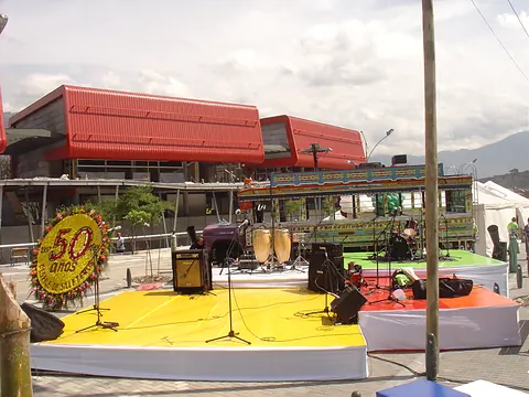 Tarima amarilla con instrumentos y una silleta conmemorativa de los 50 años del Desfile de Silleteros