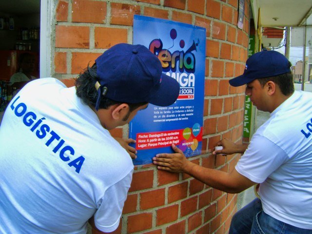 Jóvenes pegando un afiche de evento